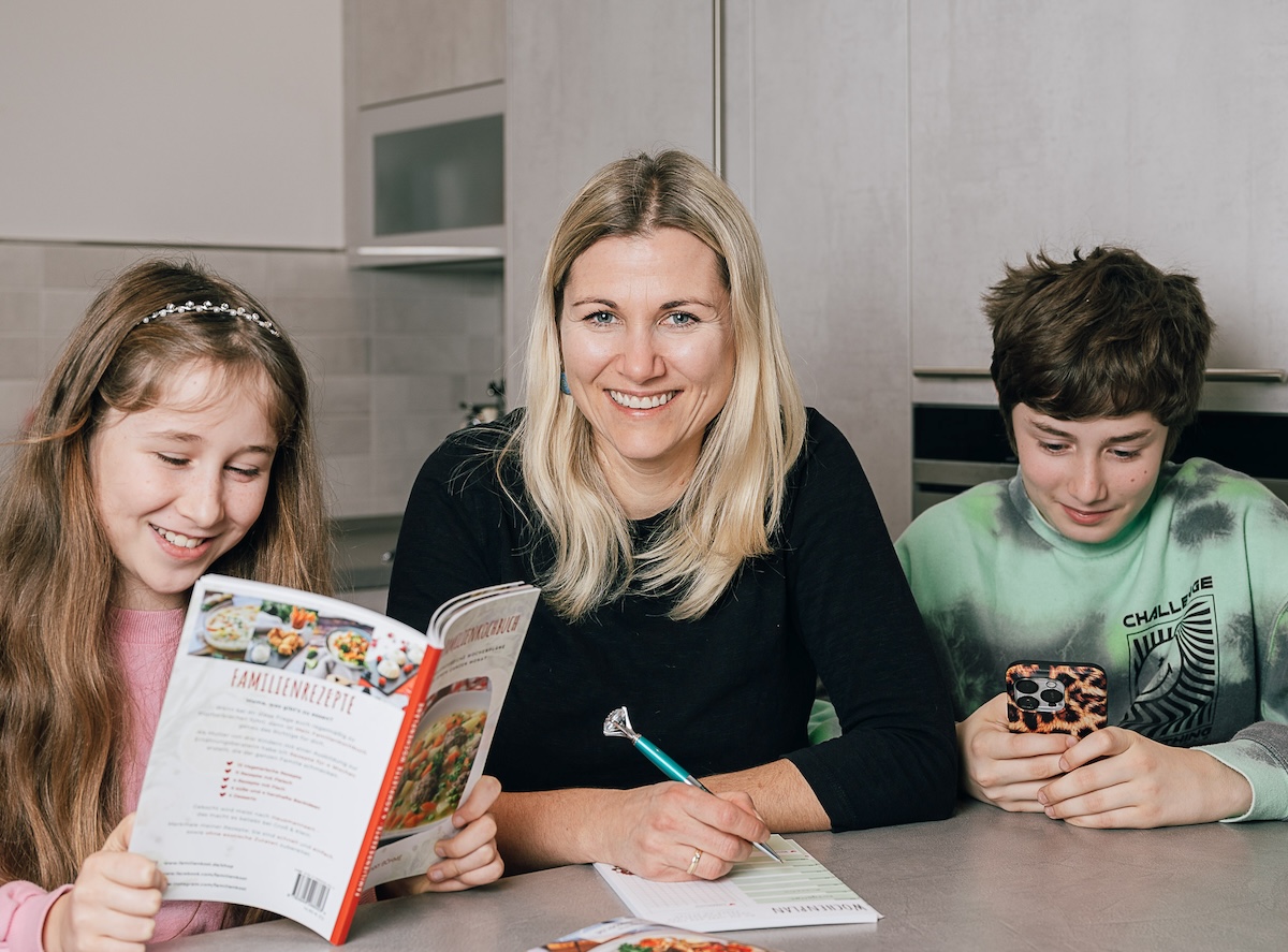 Jenny mit Emil und Frieda am Tisch in der Küche